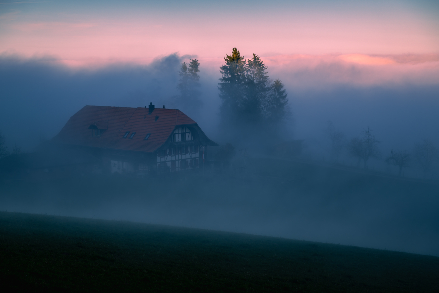Gehört in dichten, kühlen Nebelschwaden, im Hintergrund Schweizer Berggipfel im Abendrot