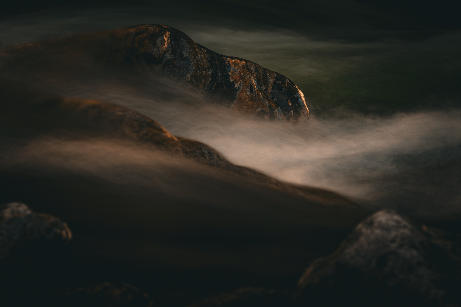 Kontrast zwischen ruhenden Steinen und fliessendem Wasser in einem Bergbach