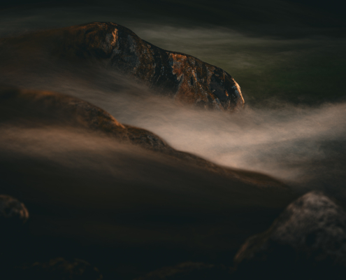 Kontrast zwischen ruhenden Steinen und fliessendem Wasser in einem Bergbach, 2. Bild einer Serie