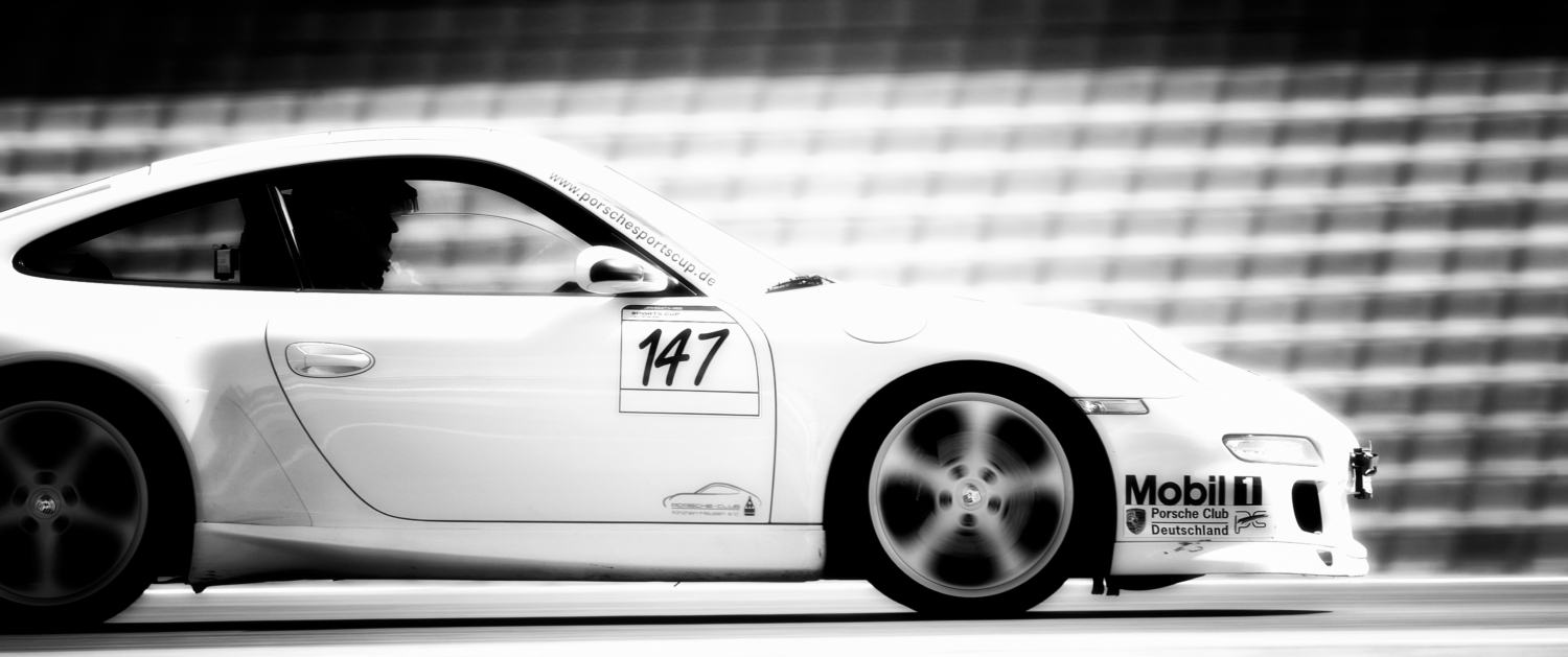 Schwarzweiss-Bild eines Porsches in schneller Fahrt auf dem Hockenheimring
