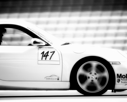 Schwarzweiss-Bild eines Porsches in schneller Fahrt auf dem Hockenheimring